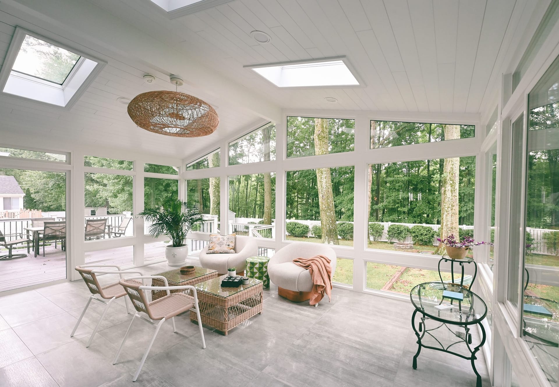 Finished four-season LivingSpace sunroom interior with floor-to-ceiling glass overlooking a wooded South Jersey backyard